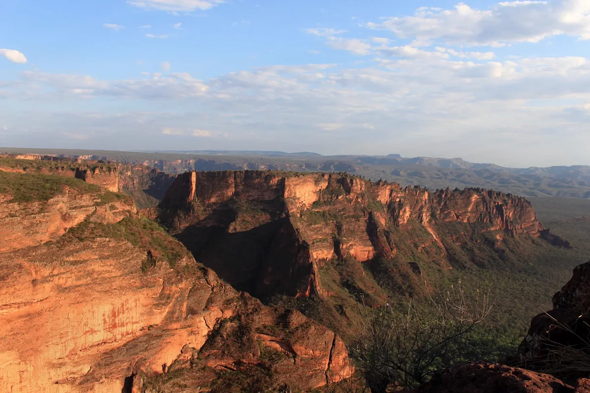 Golden sandstone walls overlooking the green valley at Cidade de Pedra